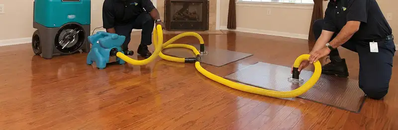 emergency water removal technicians extracting standing water from a home using professional equipment in Pittsburgh, PA